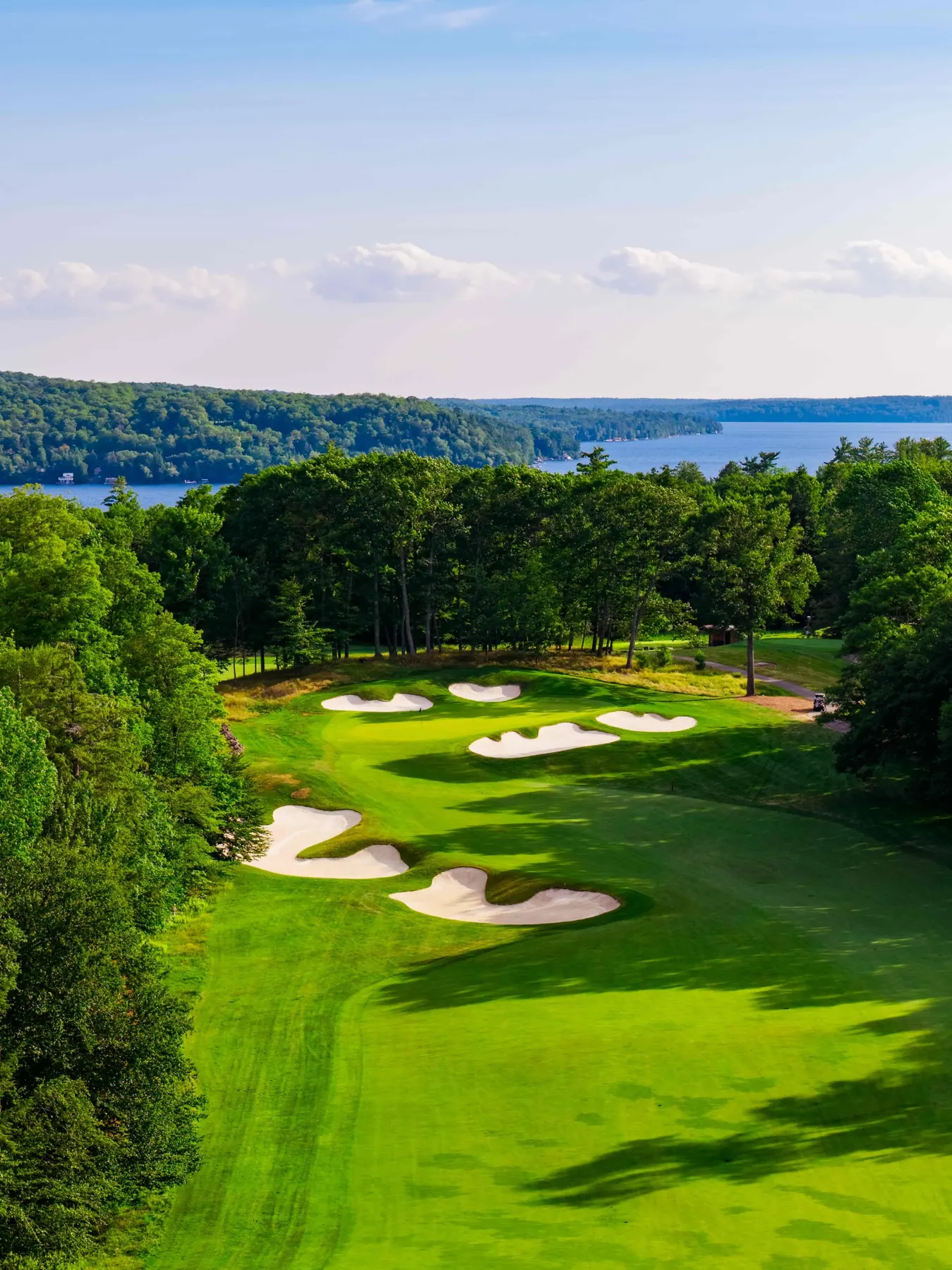 Aerial looking down a bunkered fairway toward Lake of Bays
