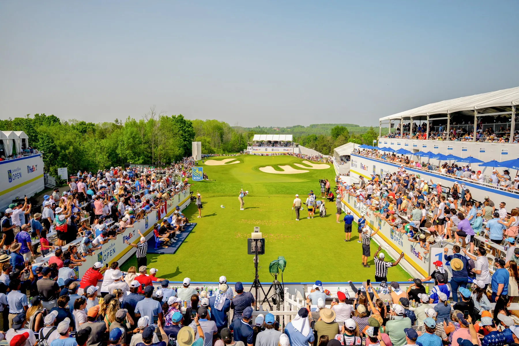 A player tees off at The Rink, surrounded by packed grandstands at the RBC Canadian Open