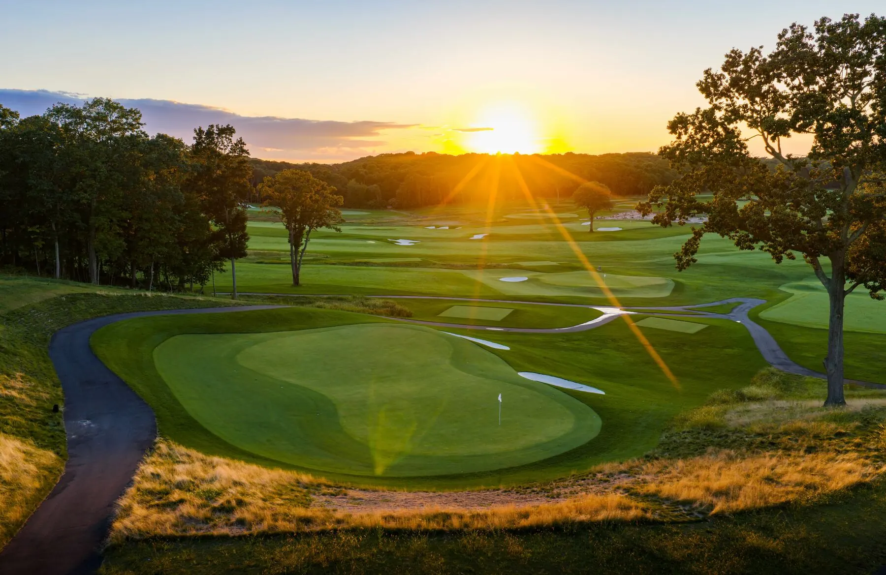 Golfers walking the course at sunrise